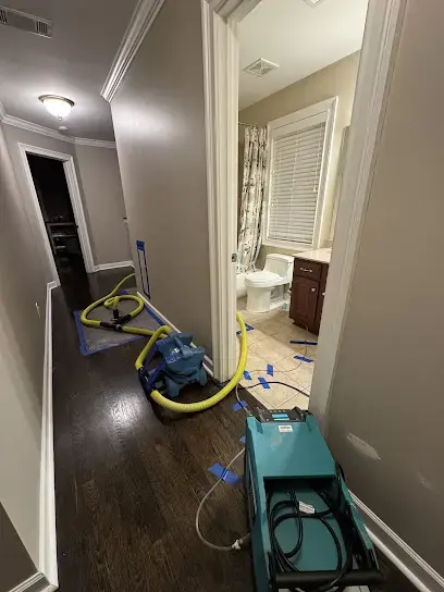 Dehumidifier and hardwood drying setup in a townhome hallway